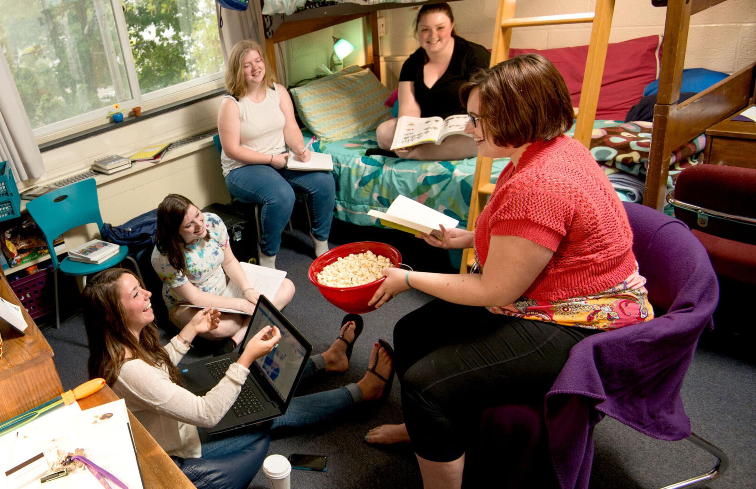一群女学生在安德森大厅的宿舍里闲逛，享受爆米花