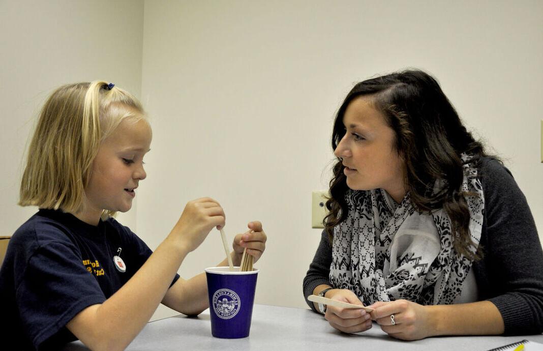 一名学生在mg冰球突破豪华版下载大学言语和听力诊所与一名儿童一起工作